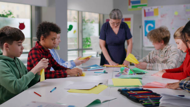 istock Multiethnic teen students having origami class at school 1554385136