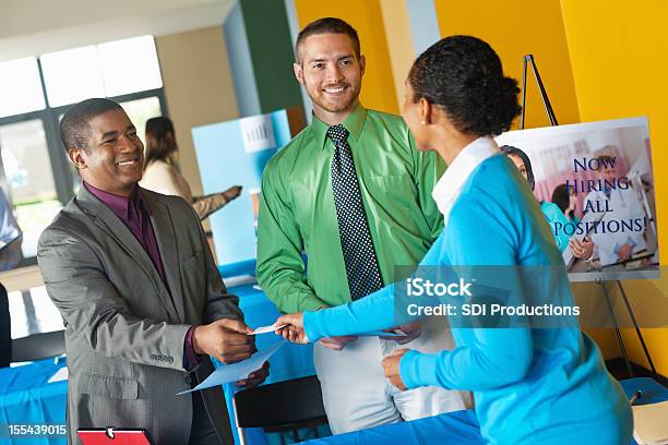 Young Professional Accepting Business Card From Team At Job Fair Stock Photo - Download Image Now