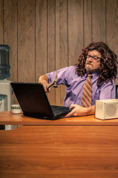 istock Aggressive Retro Office Worker Smashing his Computer with Hammer 155439229