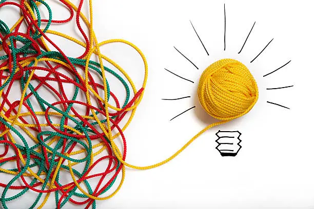 Photo of Yellow ball of wool with pen lines like lightbulb