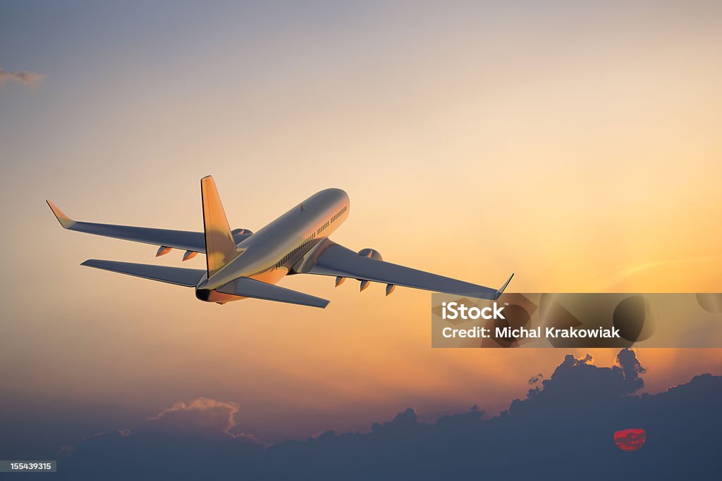 Passenger airplane flying above clouds during sunset Passanger airplane flying above clouds in evening. Airplane Stock Photo