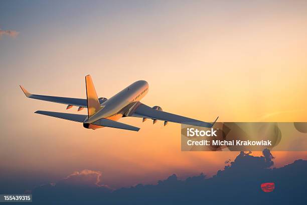 Passenger Airplane Flying Above Clouds During Sunset Stock Photo - Download Image Now