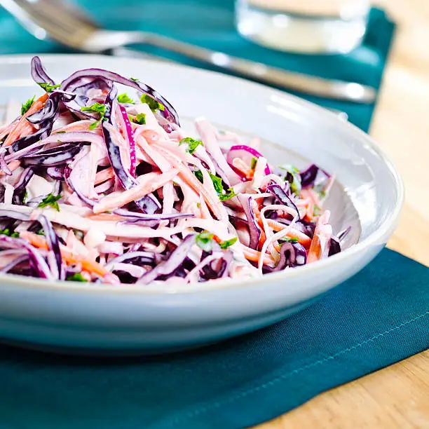 healthy salad coleslaw,made by shredded red cabbage,white cabbage,carrot,red onion,white wine vinegar and mayonaise,fine chopped parsley for garnish.