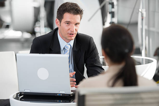 Financial Advisor Talking with His Client Financial advisor talking with his client while having meeting in the office. talking two people business talk business stock pictures, royalty-free photos & images