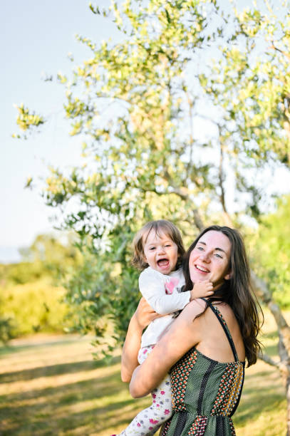 istock mother with daughter laughing in a sunny meadow. 1554393675