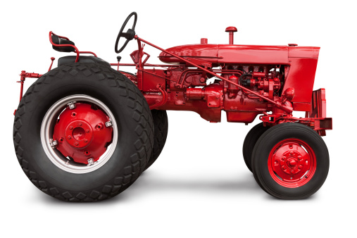Isolated profile of a newly painted old red farm tractor - Precise clipping path provided. The image was cleaned up of grass and debris in Photoshop. Canon 5D MarkII.