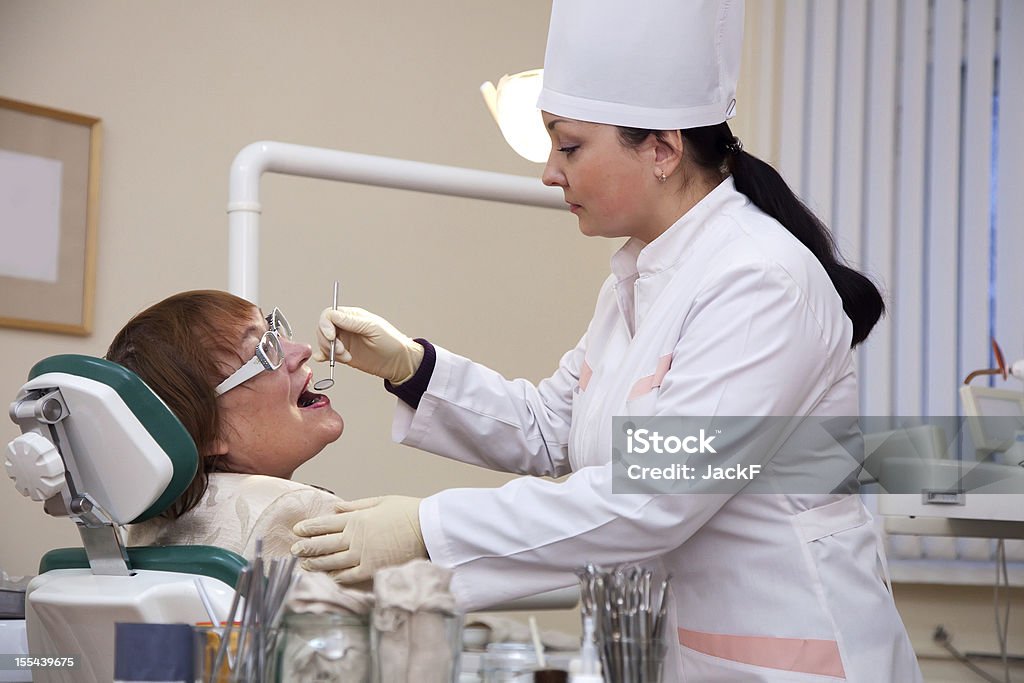 Dentist  looking  her patient Dentist  looking  her patient with tools 30-39 Years Stock Photo