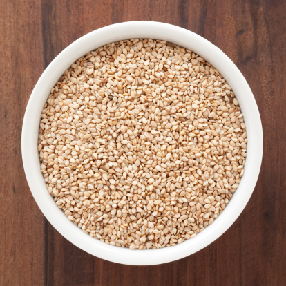Top view of white bowl full of sesame seeds