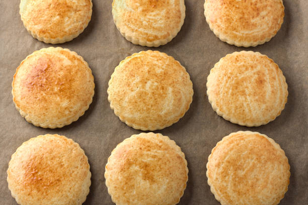 istock Freshly baked milk shortcakes on parchment, top view. DIY, step by step, step 10 1554403330