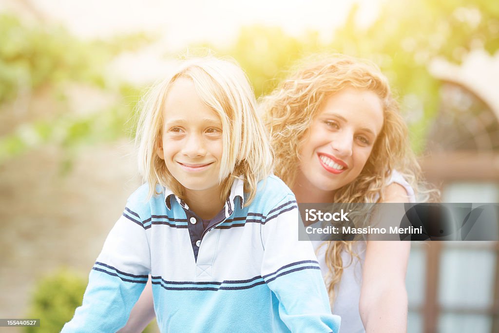 Baby-sitter con piccolo ragazzo in bicicletta all'aperto - Foto stock royalty-free di 6-7 anni