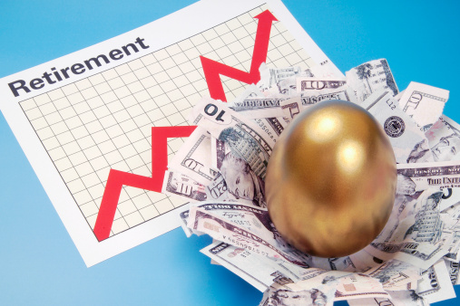 A nest has been created from money and a golden egg sits in the middle of the nest. The nest is resting on a Retirement Graph that is showing an upswing in the chart.