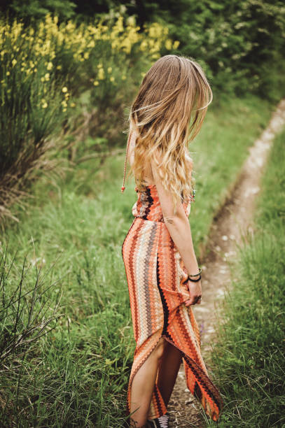 young girl in a dress standing in a spring forest.