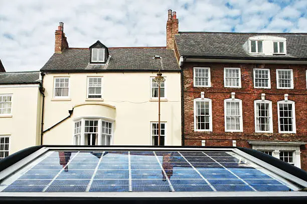 The solar panel of a parkmeter reflects the sky in a street of Durham, England