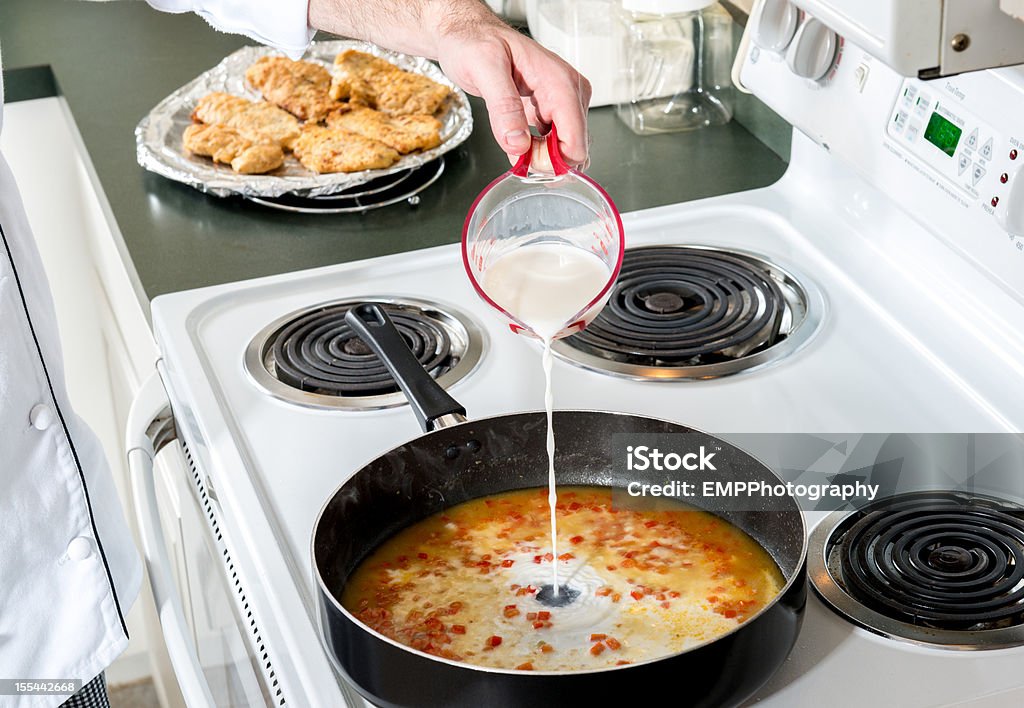 Lowfat Milk added to Red Peppers and Chicken broth Lowfat milk added to red peppers and broth- Cooking Series Chef Stock Photo