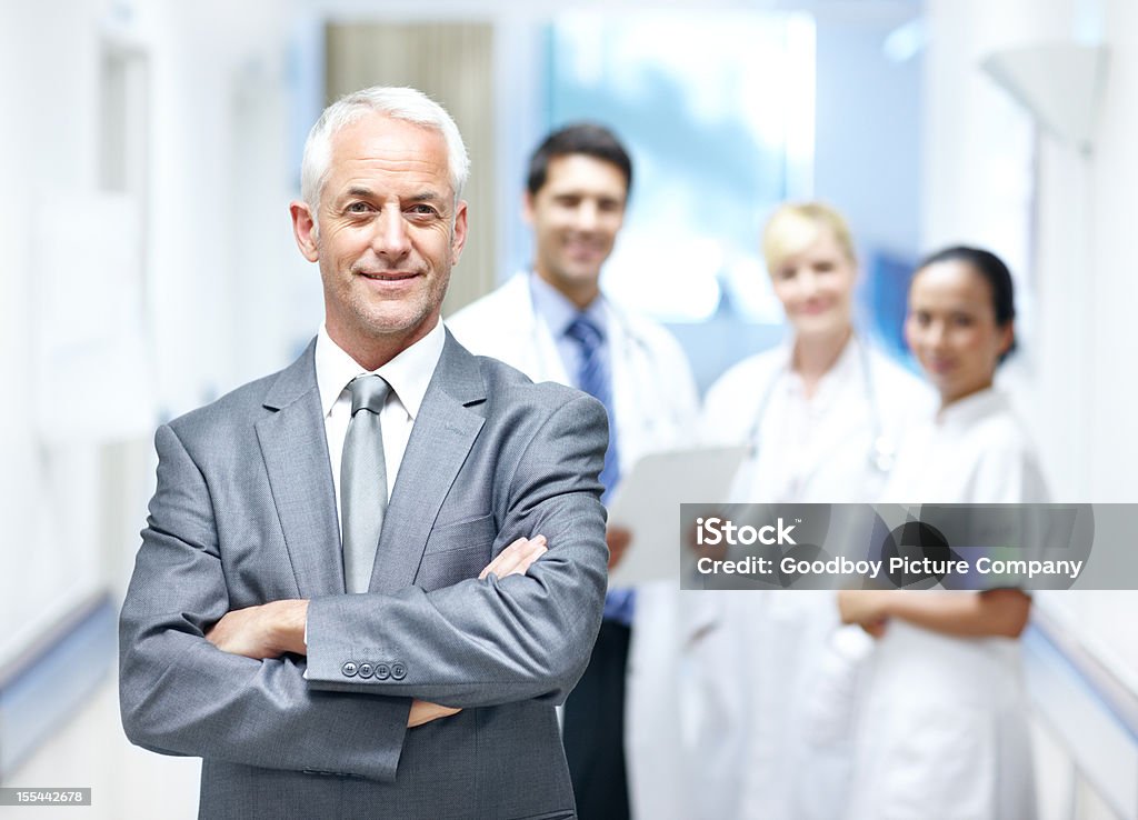 We have your best interests at heart Senior professional wearing a suit standing in front of a group of medical doctors - Copyspace Administrator Stock Photo