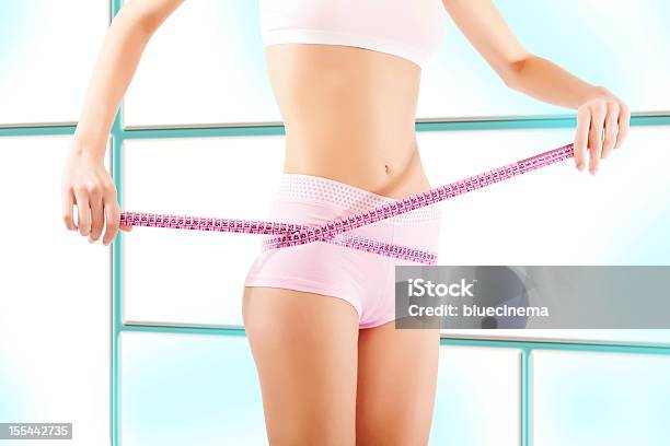 Young Woman Measuring Her Waistline Stock Photo - Download Image Now - Abdomen, Adult, Beautiful Woman