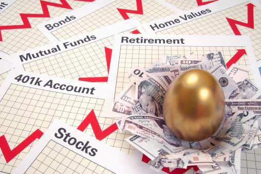 A nest has been created from money and a golden egg sits in the middle of the nest. The nest is resting on various retirement account charts and graphs.