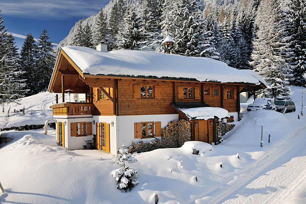 Traditional Ski Chalet covered in Snow (XXXL) First sunny day after heavy snow storms. Beautiful traditional wooden ski chalet located right by the slopes. Nikon D3X. Converted from RAW. chalet stock pictures, royalty-free photos & images