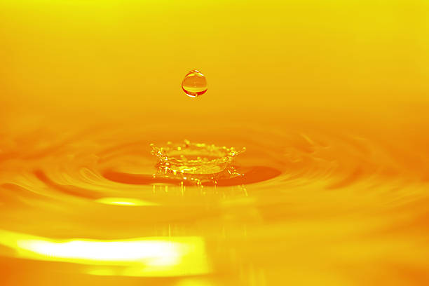 Golden Color Water Drop Background - XXXXXLarge High Speed ​ ​and High Quality Photography of Golden Color Water Drops, Studio Shoot slow motion photos stock pictures, royalty-free photos & images