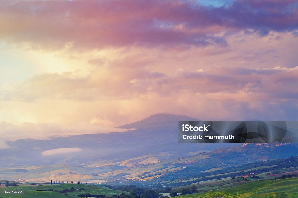 Landscape at dawn in Tuscany Landscape at dawn in Tuscany - The small town of Castiglione d'Orcia and the medieval guard tower, Rocca d'Orcia is visible in the background. The mountain is Monte Amiata, the largest of the lava domes in the Amiata lava dome in the southern Tuscany region of Italy. Awe Stock Photo