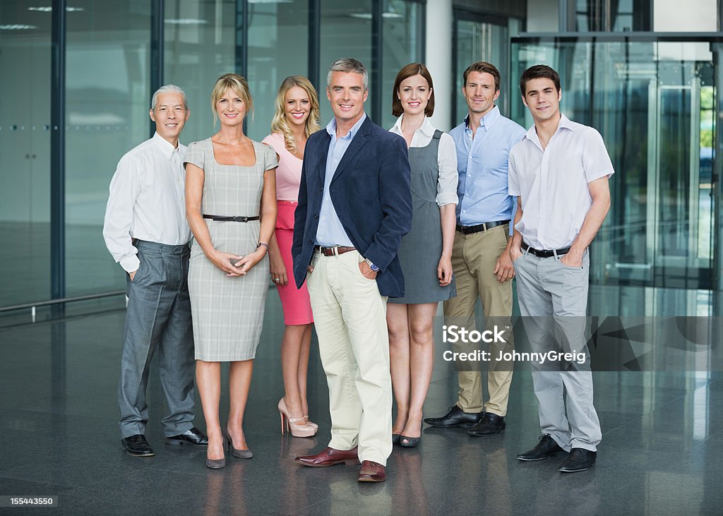 Confident Multiracial Business Professionals Full length portrait of confident multiracial business professionals standing together in office lobby Office Stock Photo