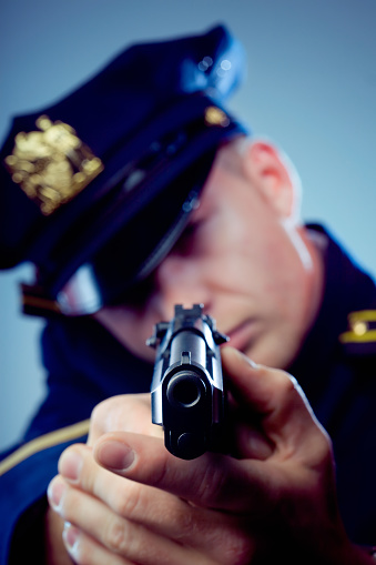 Policeman with gun drawn, aiming.