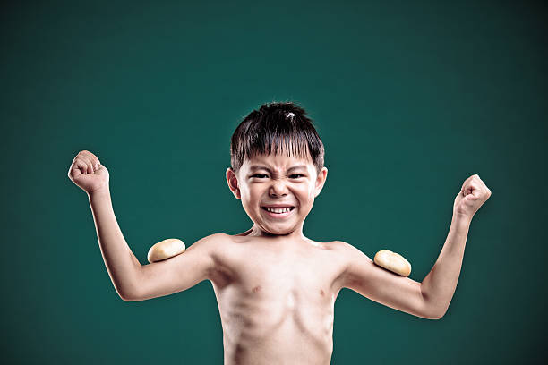 garotinho está convicto de que ele tem fortes músculos. - macho little boys flexing muscles human muscle - fotografias e filmes do acervo