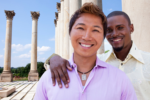 A gay couple offers hopeful smiles that the U.S. Supreme Court will ultimately affirm the rights of LGBT people to marry. This couple is posed in front of these judicial-like columns to symbolize the important marriage equality cases that are making their way up the U.S. court system. While this photo shoot was originally conceived to create concept images around the marriage equality debate, it also would be appropriate for other illustrations that require a male couple.