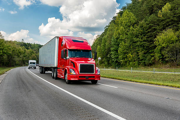 istock Red tractor trailer on a roadway through trees 155444311