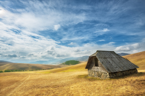 Beautiful autumn mountain landscape. Lonely cottage on a cloudy day.