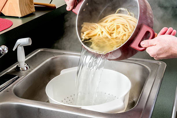 drainage fettuccine in einem sieb abtropfen - salatsieb stock-fotos und bilder