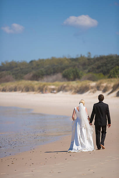 istock Newly Wed Couple Walking on the Beach 155445093