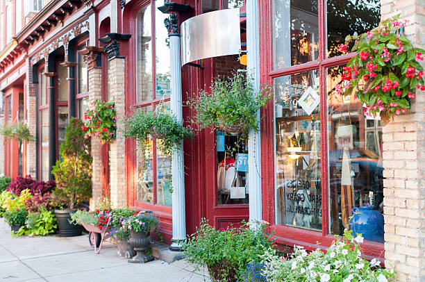 Stretch of local businesses in a historic downtown district. First storefront in focus is an antique shop.