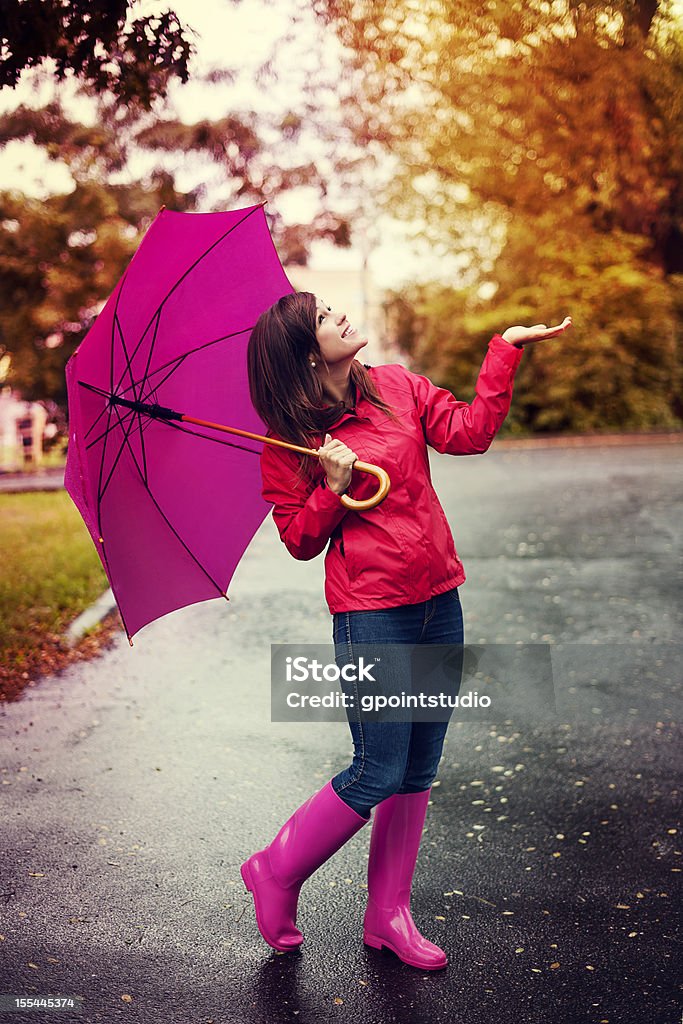 Happy woman with umbrella checking for rain in a park  Monsoon Stock Photo