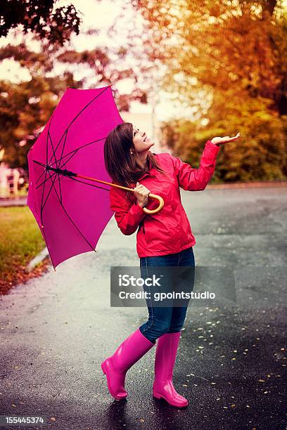 Happy Woman With Umbrella Checking For Rain In A Park Stock Photo - Download Image Now