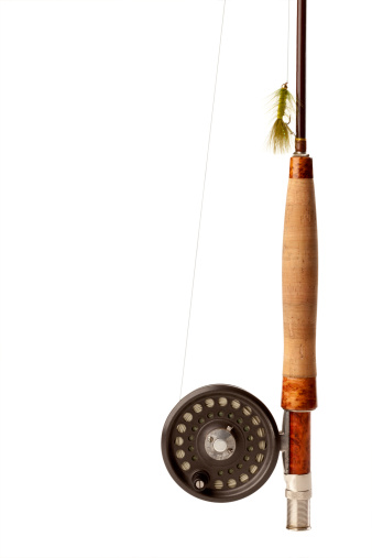 Close up of the handle of a fly-fishing rod & reel with a green  fly. Copy Space on the left, rotate or rotate the image to fit your layout.