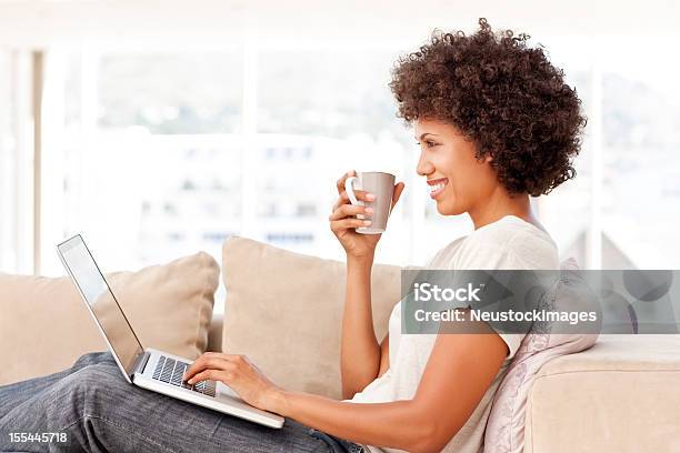 リラックスした女性のノートパソコンを使う - アフリカ民族のストックフォトや画像を多数ご用意 - アフリカ民族, ソファ, ノートパソコン