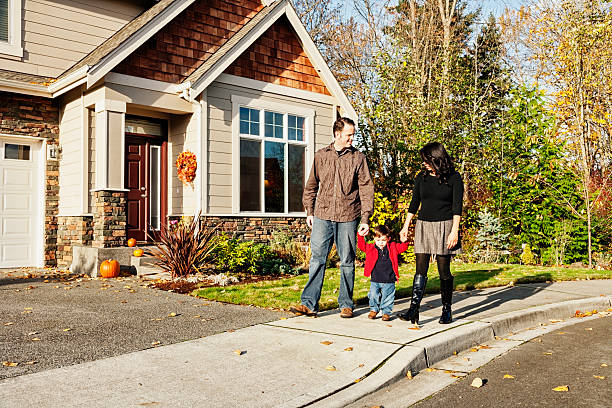 Young Family Coming Home From a Walk Photo of a young family taking a neighborhood stroll with their toddler, returning home. small town photos stock pictures, royalty-free photos & images