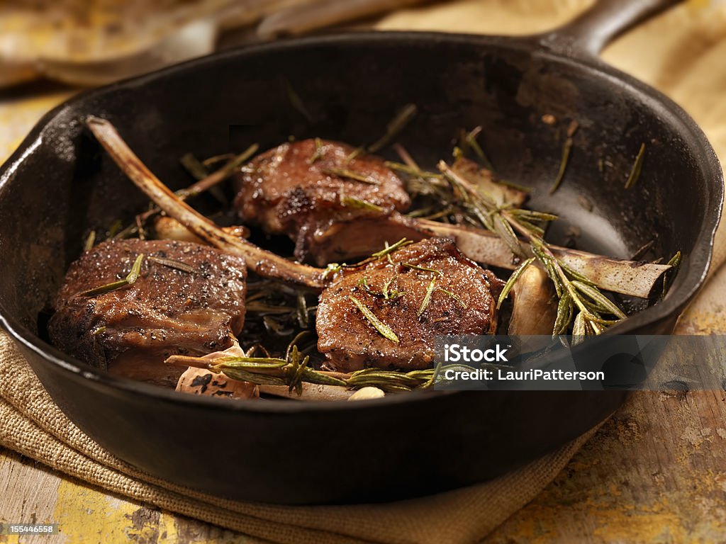 Braised Lamb Chops Rack of Lamb with Garlic, Rosemary and Peppercorns in a Cast Iron Skillet- Photographed on Hasselblad H3D2-39mb Camera Lamb Chop Stock Photo