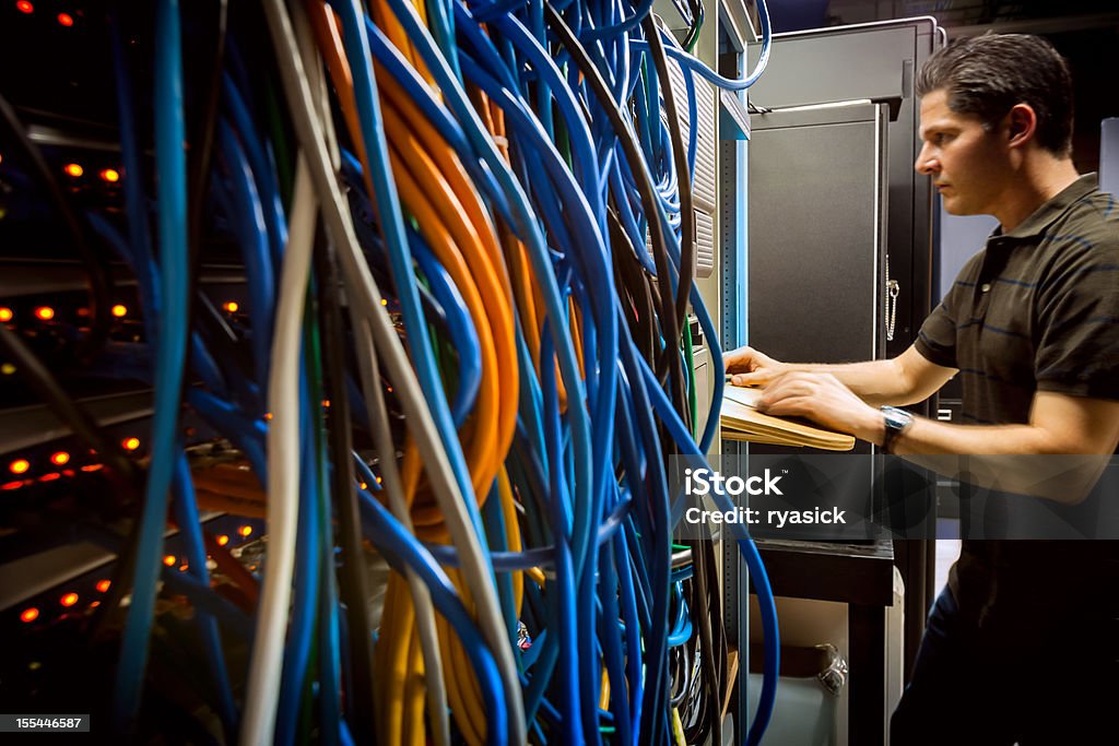 Ce technicien dans la salle de serveur de matériel informatique - Photo de Programmeur libre de droits