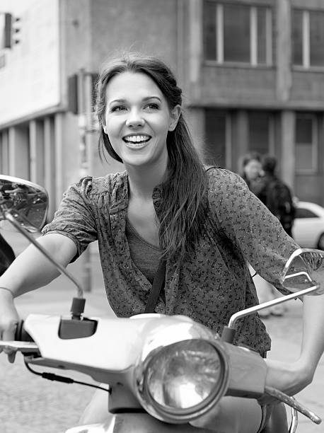 istock smiling young woman on scooter 155446614