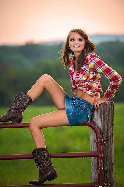 красивые ковбой-девушка, сидящая на загон забор - female04 стоковые фото и изображения