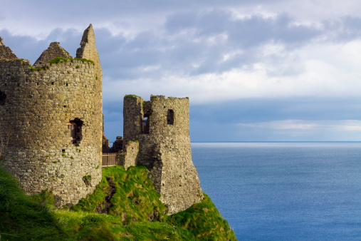 Dunluce Castle is a now-ruined medieval castle in Northern Ireland. It is located on the edge of a basalt outcropping in County Antrim (between Portballintrae and Portrush), and is accessible via a bridge connecting it to the mainland. The castle is surrounded by extremely steep drops on either side, which may have been an important factor to the early Christians and Vikings who were drawn to this place where an early Irish fort once stood.