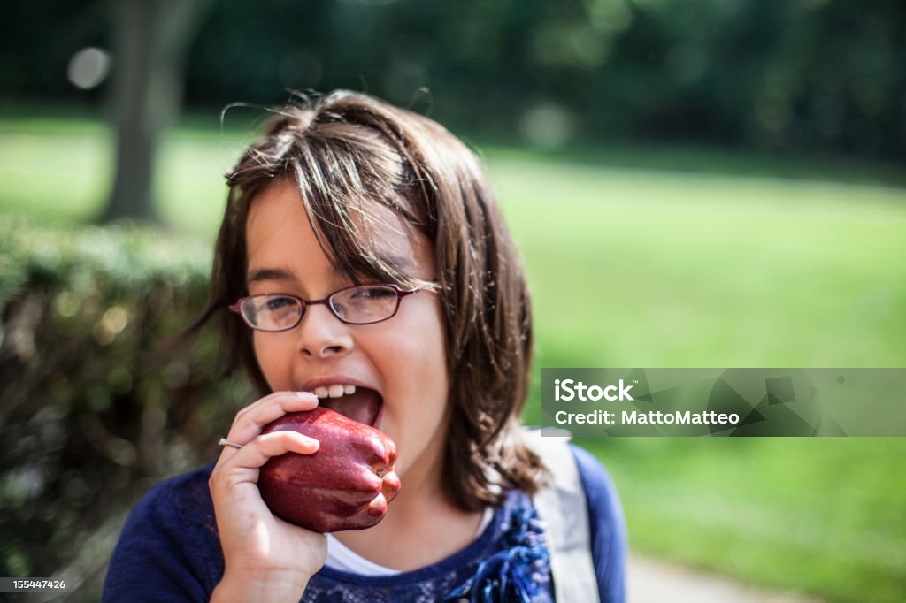 Chica está comiendo una manzana - Foto de stock de 12-13 años libre de derechos