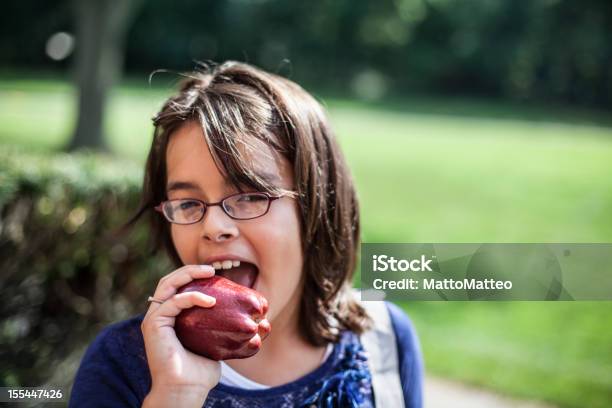 Chica Está Comiendo Una Manzana Foto de stock y más banco de imágenes de 12-13 años - 12-13 años, Comer, Niño