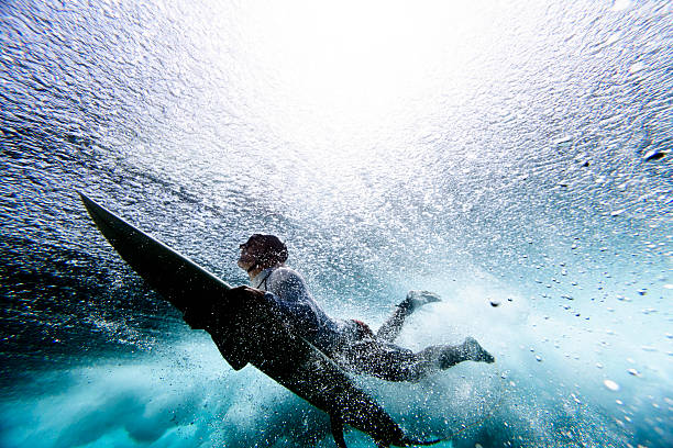 серфер duck дайвинг - surfing surf wave extreme sports стоковые фото и изображения