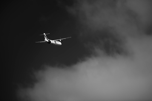Black and white shot of airplane in mid-air.