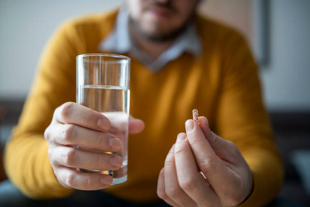 istock Close-up shot of a man taking vitamin pill. 1554518698