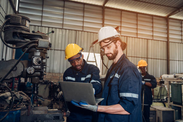 istock Team of engineers and technician using laptop checking and repair pressing metal machine at factory. 1554520105
