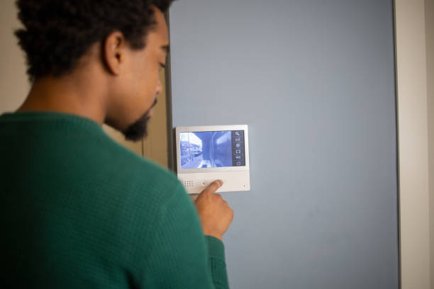 istock Young man adjusts the temperature at home with a device on the wall 1554523633